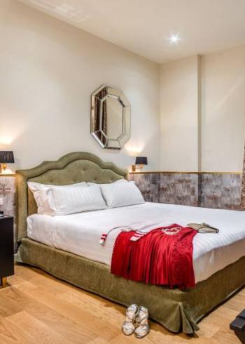 Camera elegante con letto matrimoniale, arredamento moderno e dettagli raffinati.