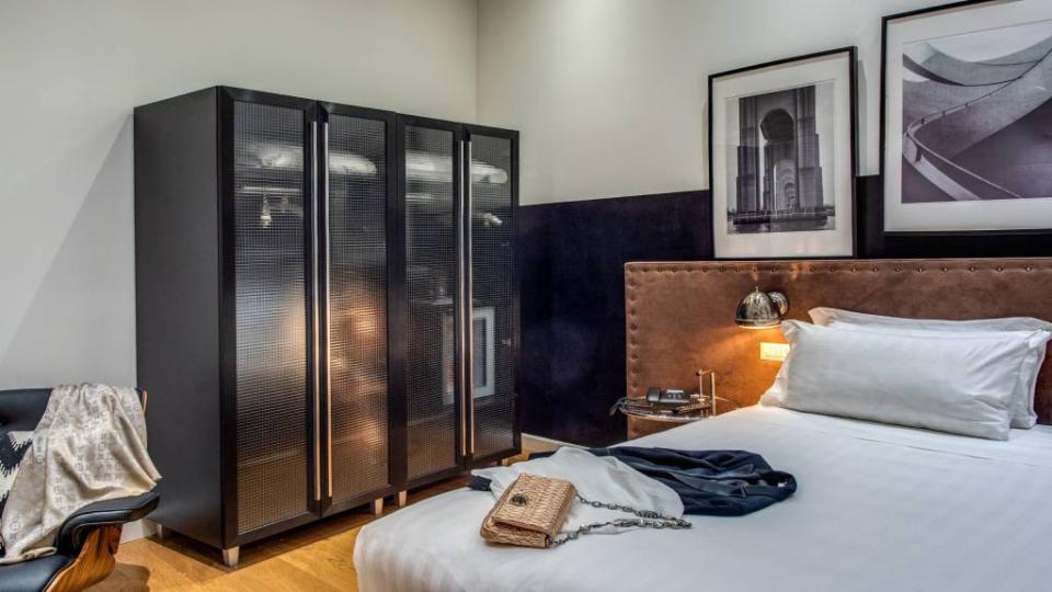 Camera moderna con armadio nero, letto accogliente e decorazioni eleganti.