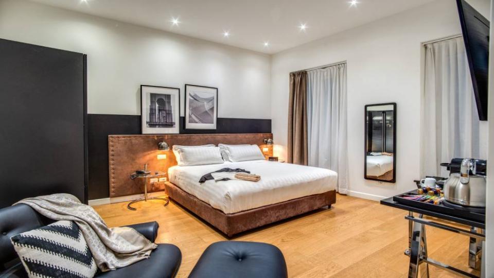 Camera moderna con letto matrimoniale, decorazioni eleganti e pavimento in legno.