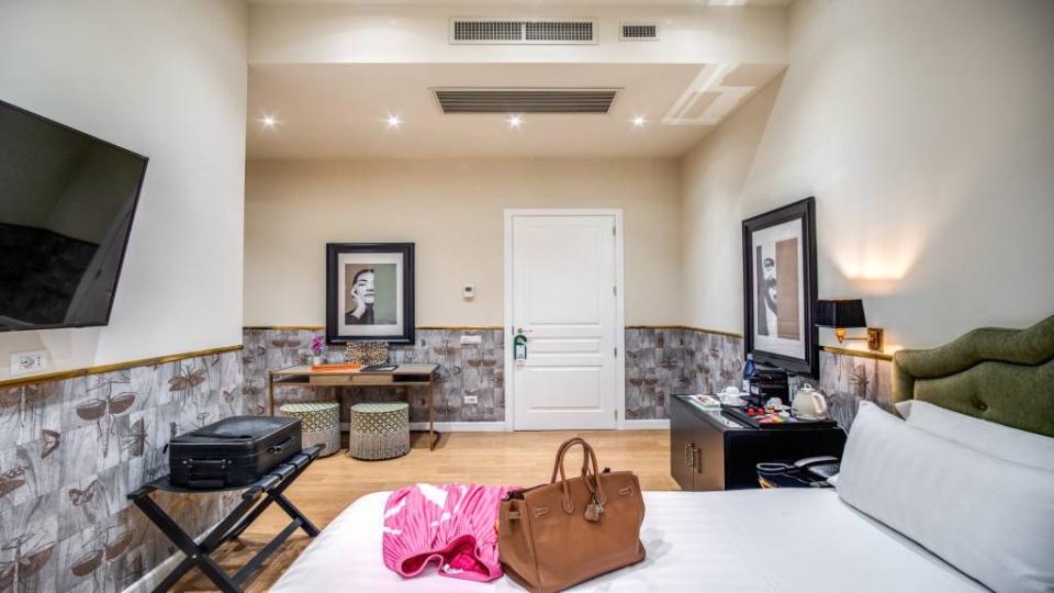 Camera d'albergo elegante con arredi moderni e opere d'arte alle pareti.