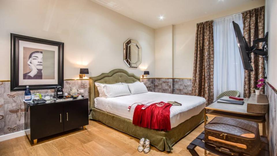 Camera elegante con letto matrimoniale, arredo raffinato e dettagli di design.