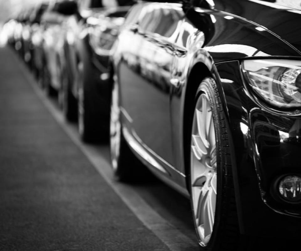 Auto nere parcheggiate in fila, evidenziando i fari e cerchi in bianco e nero.